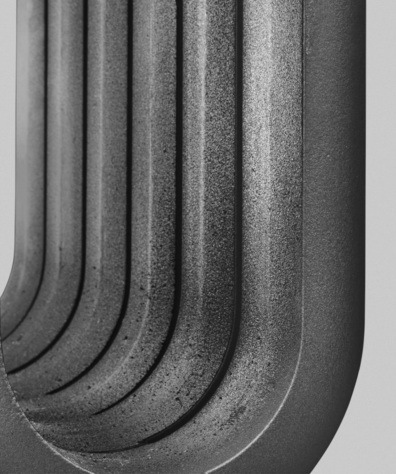 B&M : détail du radiateur en fonte anthracite avec de larges modules arrondis. On voit l'intérieur creux. Design Suisse Bertille Laguet. Fabrication française.