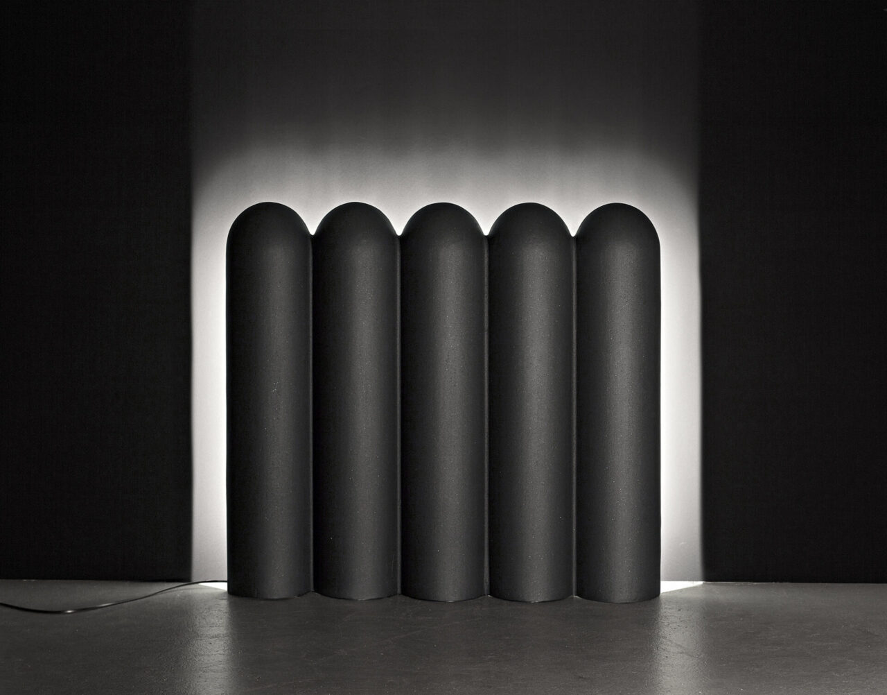 Caleo : objet lumineux allumé en fonderie d'aluminium gris anthracite. Design suisse Bertille Laguet. Fabrication française par l'artiste elle-même.