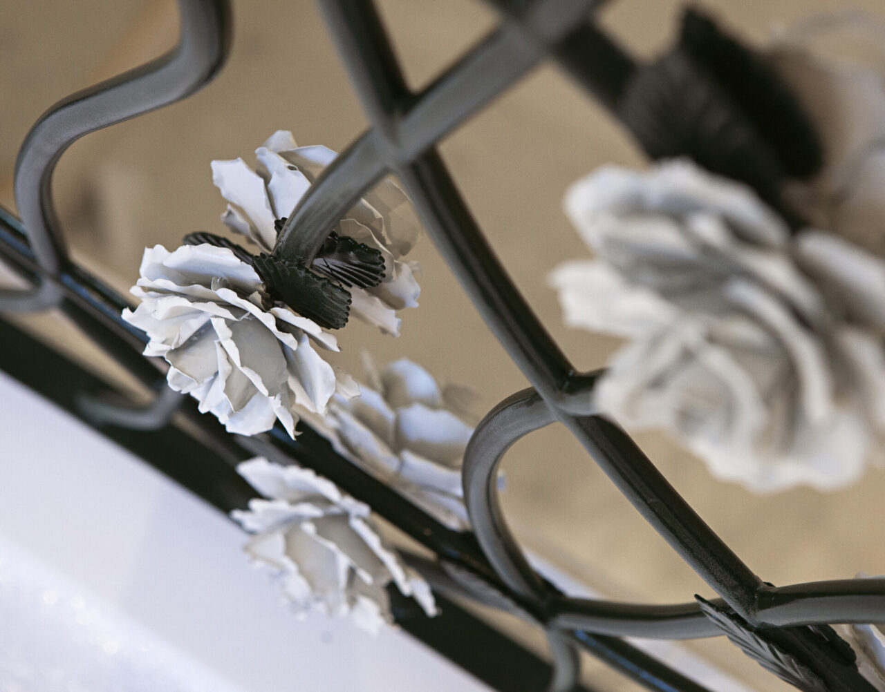 La roseraie : rampe d'escalier en fer forgé vert foncé garni de roses blanches. Design et fabrication Bertille Laguet